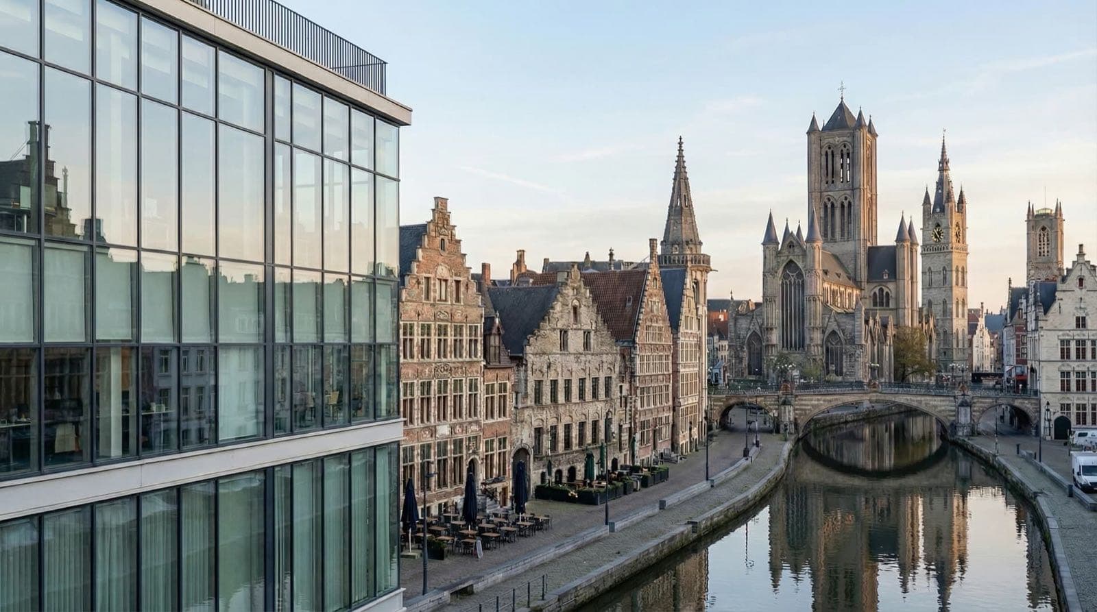 Des façades en briques et des tours se reflètent dans un canal urbain.